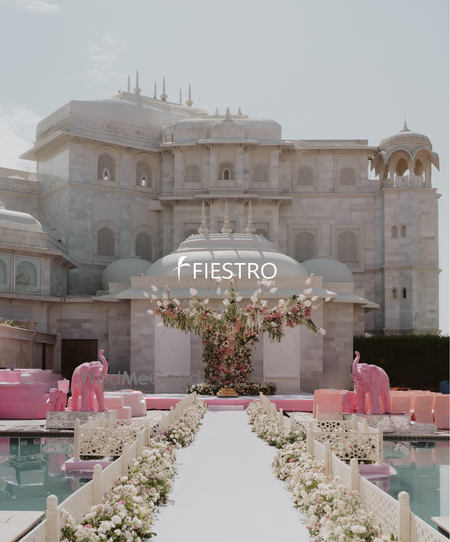 Photo of Lovely white floral aisle and open mandap with pink elephants at a palace venue