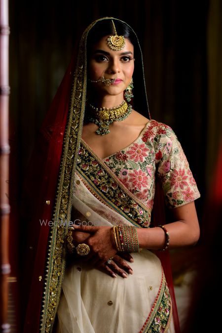 Photo of Indian bride wearing floral lehenga with minimal jewellery for wedding