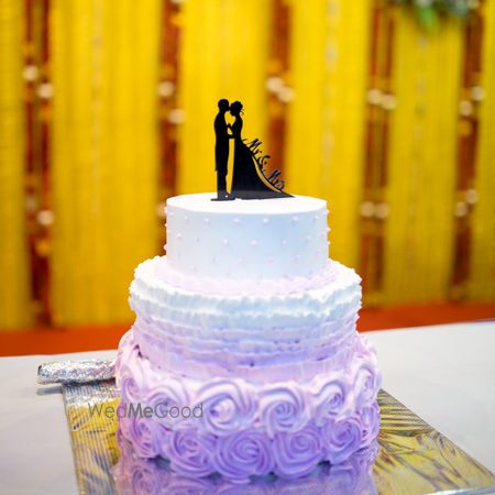 Photo of White and lavender small wedding cake with couple cake topper