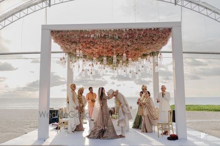 Photo of Destination wedding mandap shot with a gorgeous floral ceiling and hanging decor elements