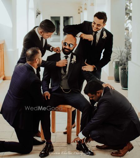 Photo of groom with his groomsmen getting ready shot