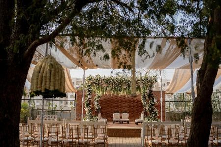 Photo of Lovely outdoor mandap with white florals and foliage for a day wedding