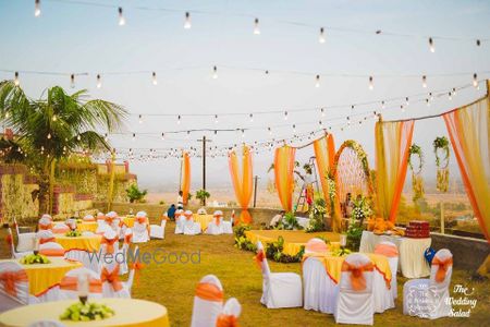 Photo of Orange and yellow theme outdoor round table setting