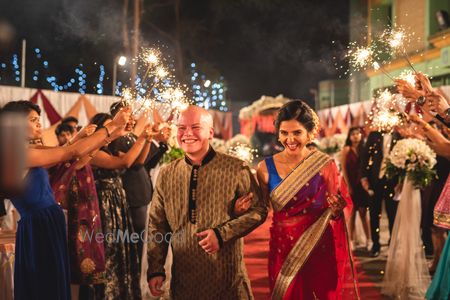 Photo of Bride and groom entry or exit with guests holding sparklers