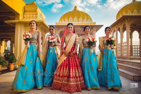 Photo of Bridesmaids in same outfits holding bouquet with the bride.