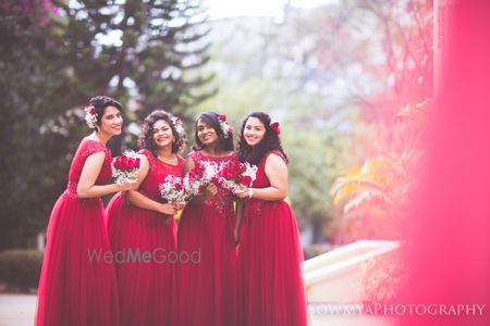 Photo of Color co-ordinated Christian bridesmaids wearing plum color gowns