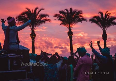 Photo of sunset baraat photo with groom dancing