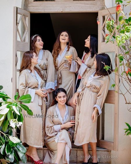 Photo of bride and bridesmaids wearing matching robes for bachelorette