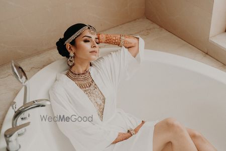 Photo of bridal getting ready shot idea in robe sitting in bathtub