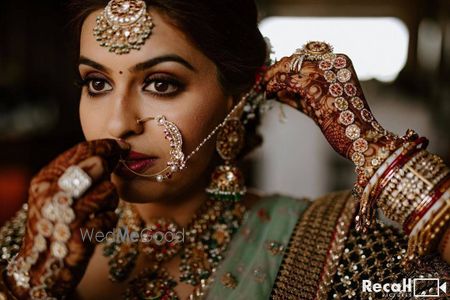 Photo of bridal close up shot with her putting on her nath