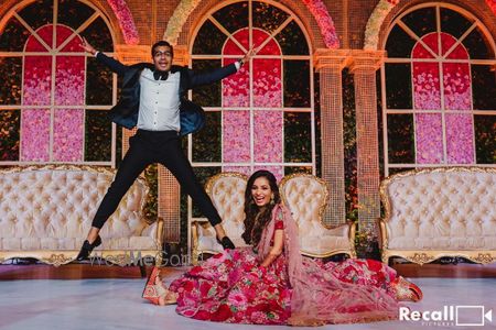 Photo of bright and happy couple shot on reception stage