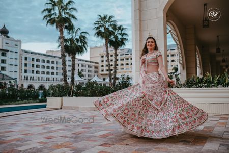 Photo of bride twirling in a pretty pastel mehendi lehenga