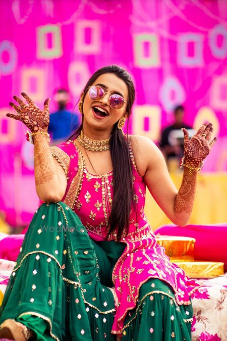 Photo of happy bride shot in dark green and pink mehendi outfit