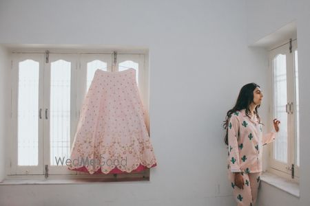 Photo of bride in night suit with lehenga on hanger