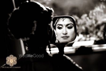 Photo of bride looking in the mirror shot