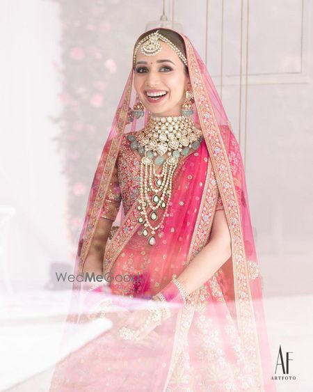 Photo of Bride wearing an elaborate choker with pink lehenga.