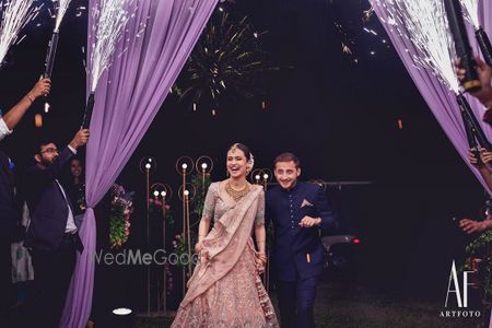 Photo of Bride and groom walking hand in hand.