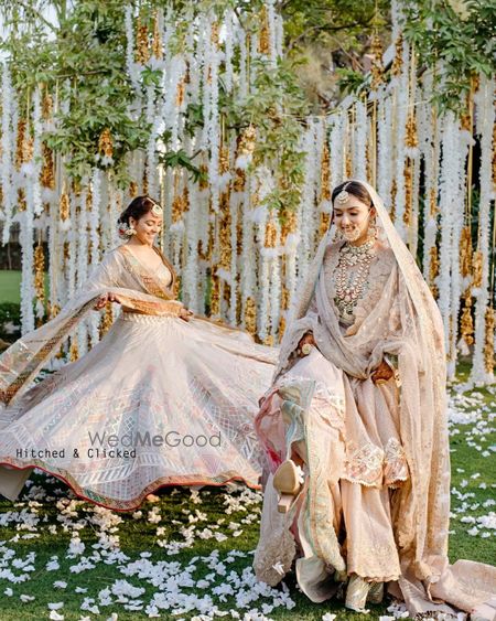 Photo of twirling bride with her sister in pastels