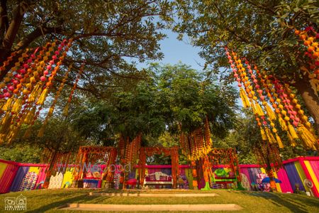 Photo of Mehendi decor with hanging gota strings from trees