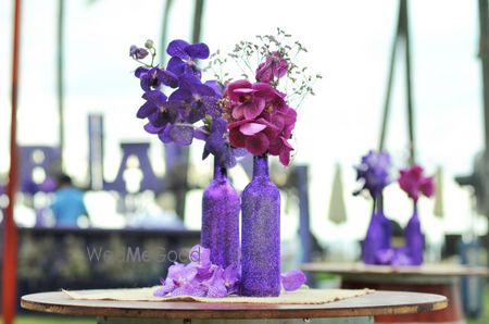 Photo of Purple bottle and flower centerpiece with flowers