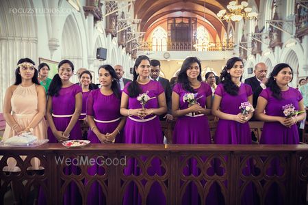 Photo of color co-ordinated bridesmaids wearing purple gowns