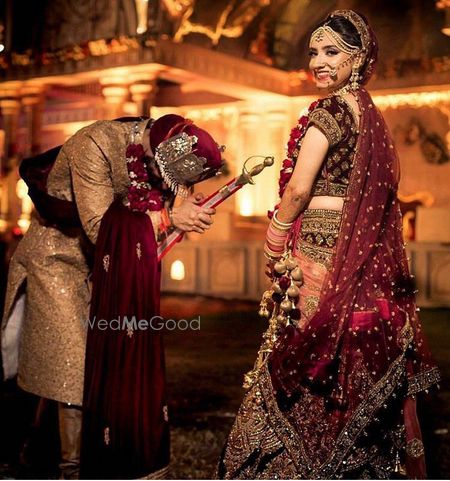 Photo of wine and gold bridal lehenga