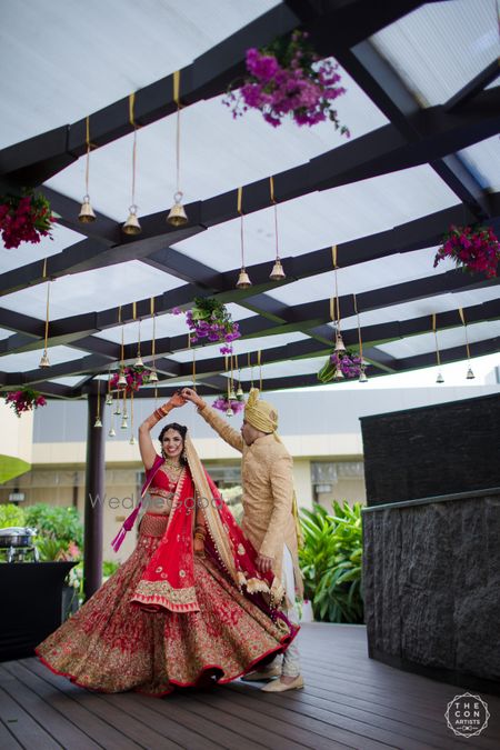 Photo of Groom making bride in pink twirl on wedding