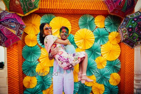 Photo of Holi party for mehendi with bride and groom against photobooth