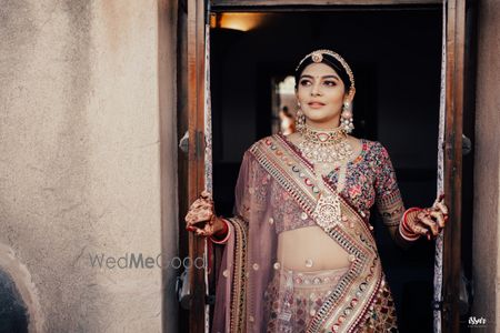 Photo of Gorgeous bride in exquisite jewellery & multi coloured lehenga