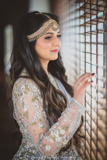 Photo of Bride looking out of window wearing mathapatti