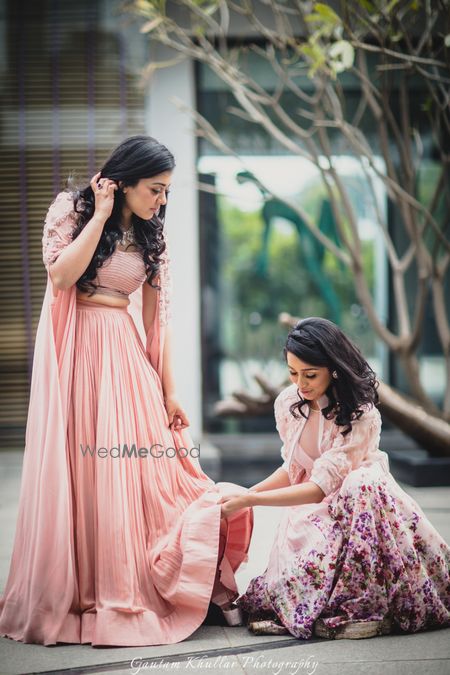 Photo of Bridesmaid helping bride shot