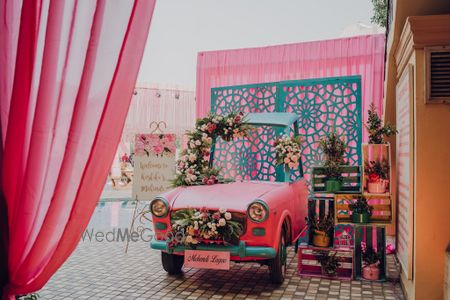 Photo of A car photobooth with some wooden boxes and floral arrangements.