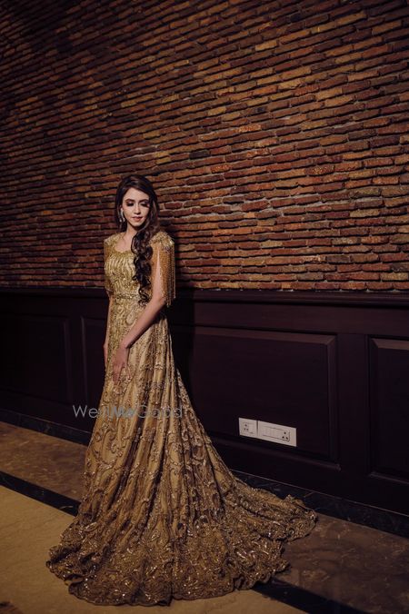 Photo of Bride wearing a gold floor-dusting gown.