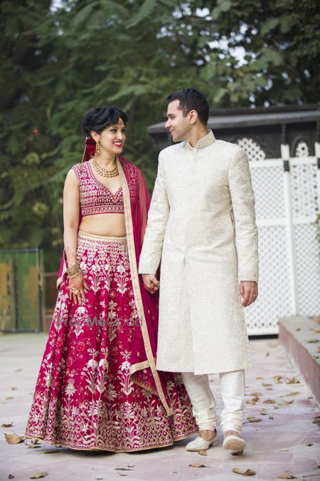 Photo of Matching bride and groom with bride in maroon and groom in white