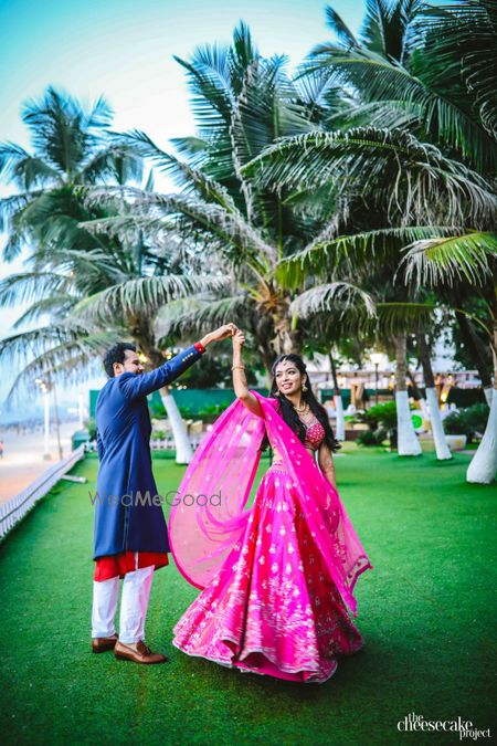 Photo of Bright pink engagement lehenga with twirling bride