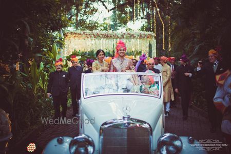 Photo of Groom entering in a white vintage car