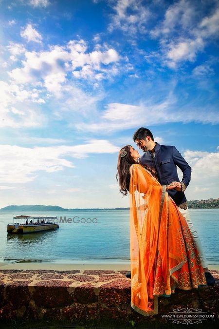 Photo of Couple portrait in orange mehedi lehenga