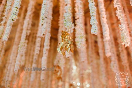 Photo of White hanging floral strings with gold leaves