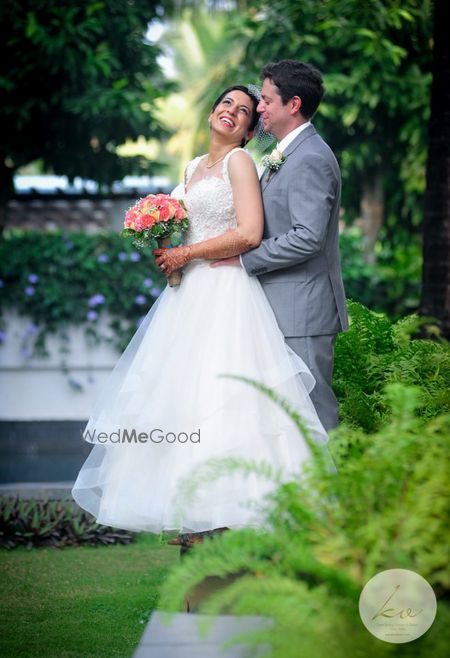 Photo of A Christian couple poses with a bouquet