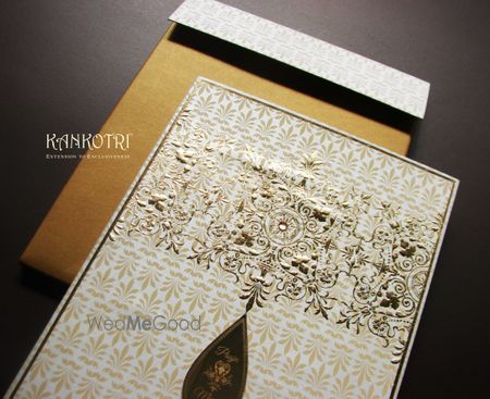 Photo of white and gold invitations