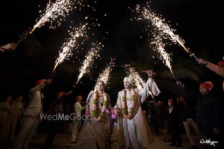 Photo of Couple entry idea with guests holding cold pyros