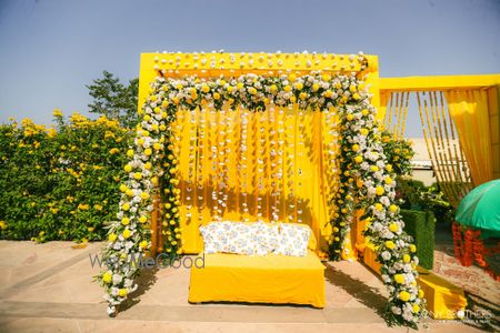 Photo of Yellow, green and white themed haldi seating decor