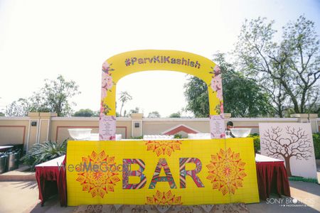 Photo of Fun and quirky haldi and mehendi bar setup with wedding hashtag in decor