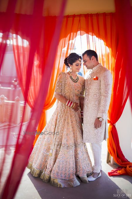 Photo of Bride and groom in matching cream outfits