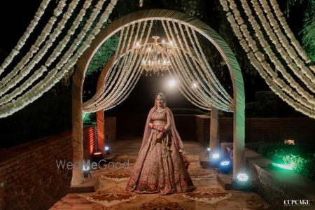 Photo of Bride standing against the wedding entrance