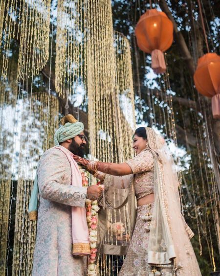 Photo of Jaimala shot with matching bride and groom