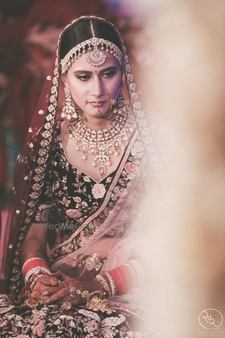 Photo of Dark bridal lehenga with pretty jewellery