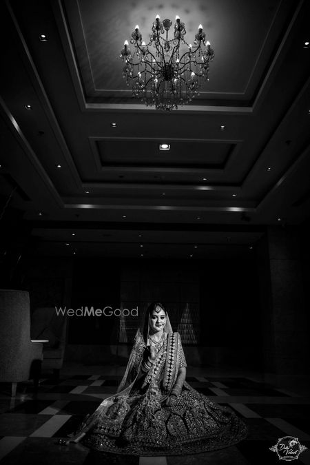 Photo of Timeless black and white bridal portrait under chandelier