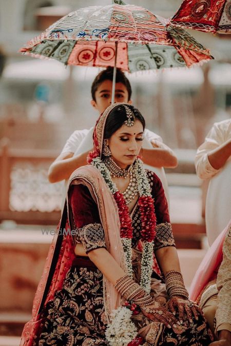 Photo of Bride entering under traditional umbrella