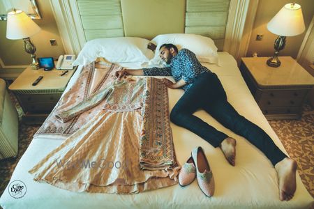 Photo of Groom getting ready shoot on bed